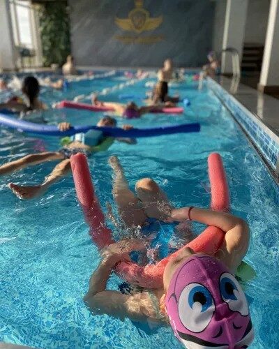 Trener sa detetom u bazenu